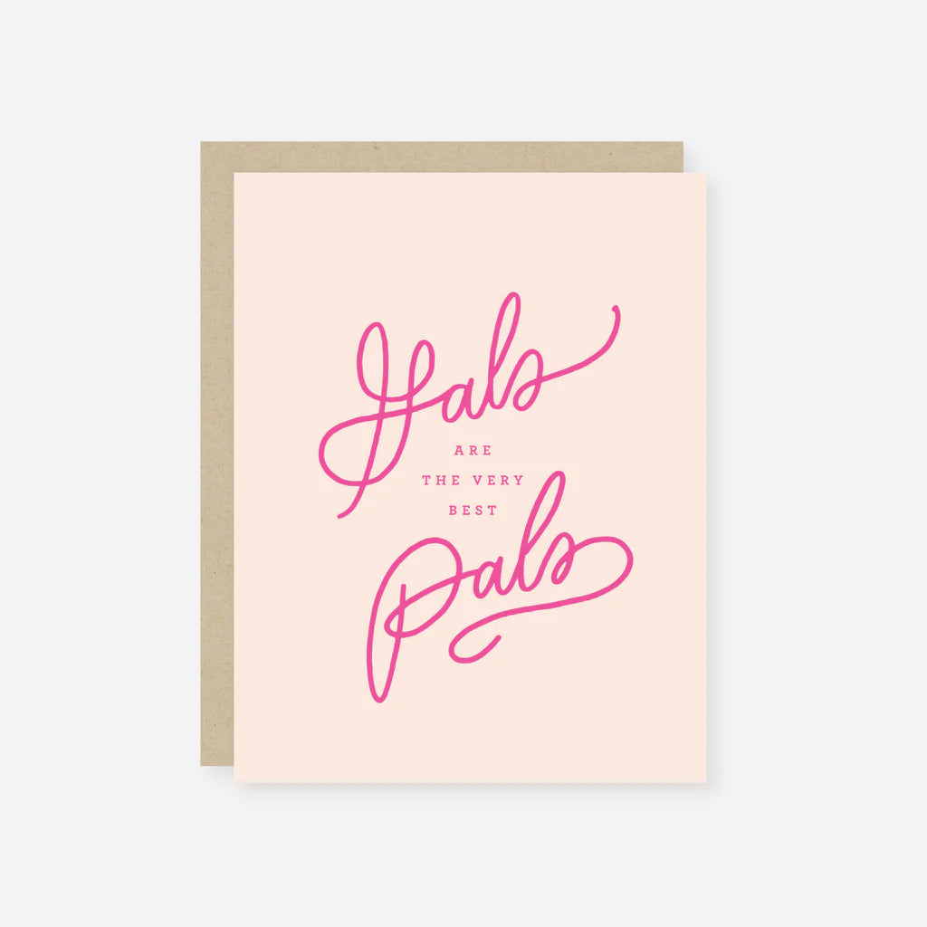 A pink greeting card with 'Gal pals are the best PALS' written in cursive script, accompanied by a matching beige kraft envelope.