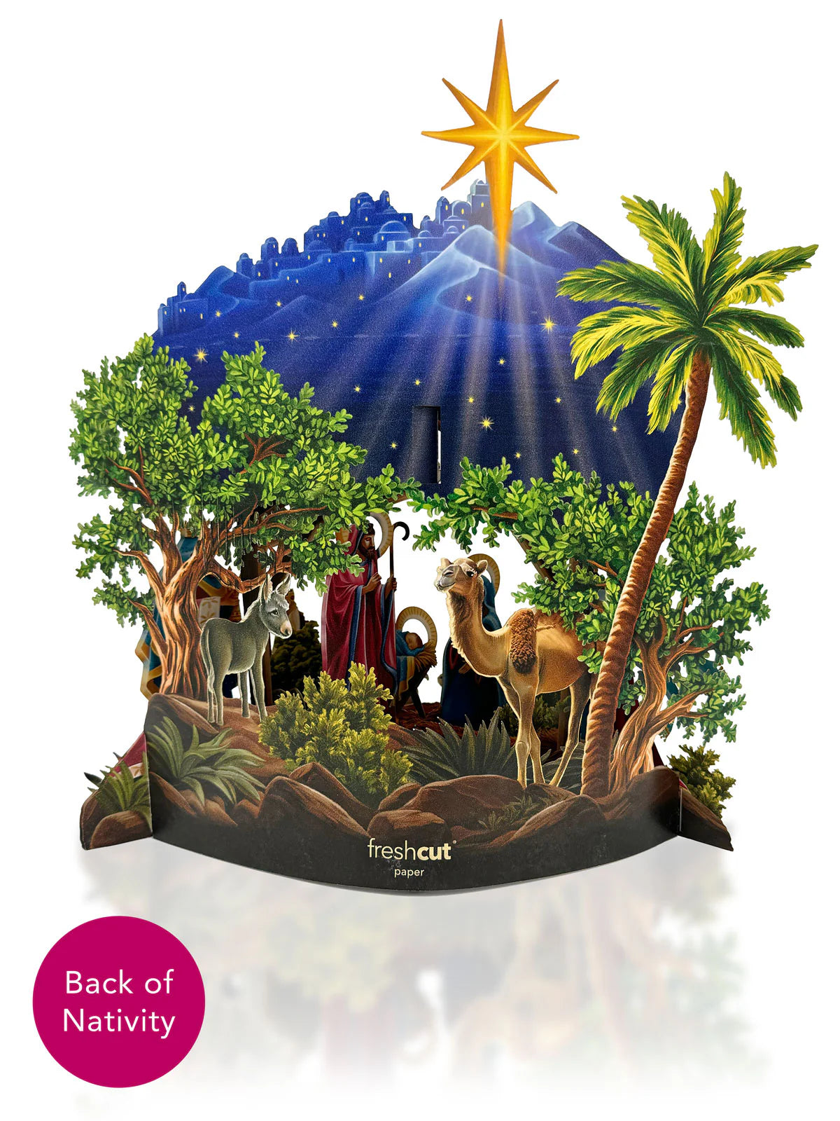 Image shows the back of the three dimensional nativity scene. Shown are cypress trees and a palm tree, along with a camel and a donkey. Joseph and the baby Jesus are also visible from this angle.