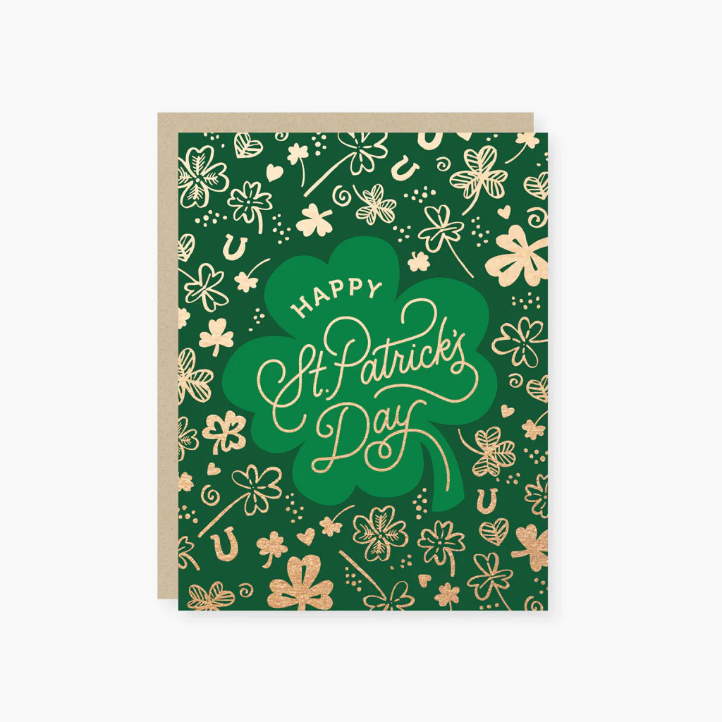 A greeting card with a green background and gold foil designs, including shamrocks and the text 'Happy St. Patrick's Day'.