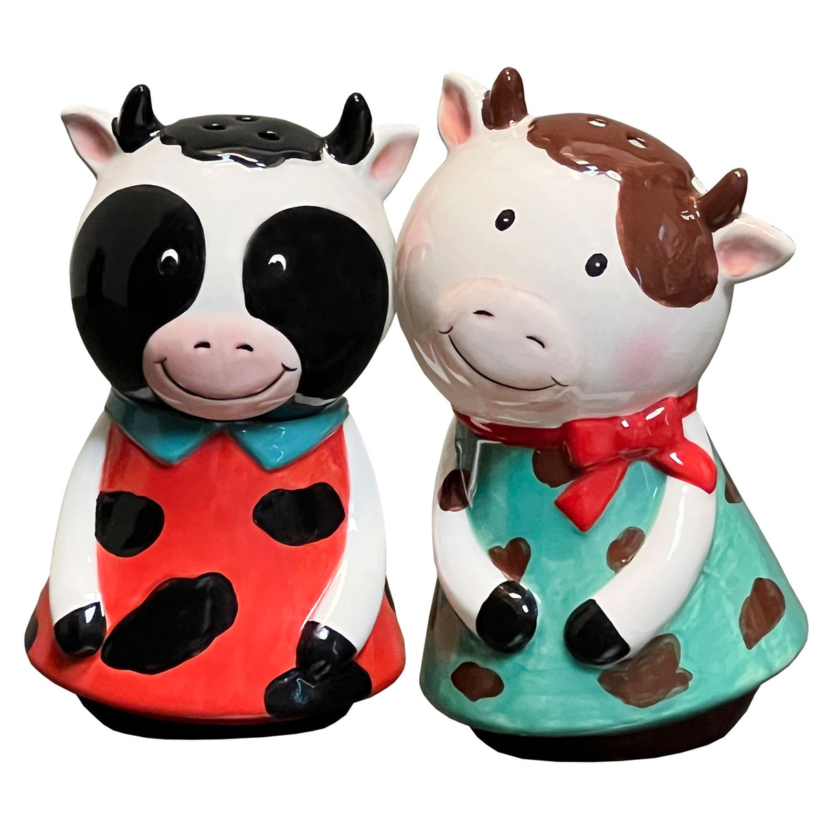 Two cow-themed salt and pepper shakers on a white background