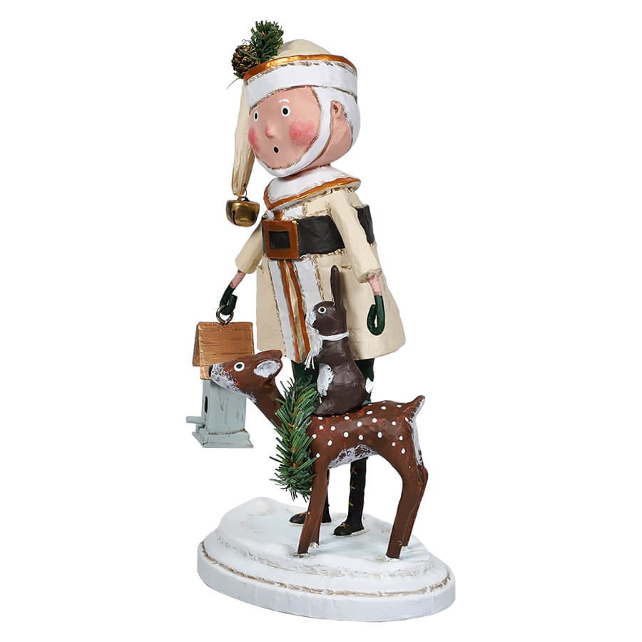 A whimsical figurine of Santa Claus wearing a green hat and a beige coat with brown fur, holding a blue birdhouse, and accompanied by a reindeer. The reindeer has a green and white color scheme with a bow on its head.