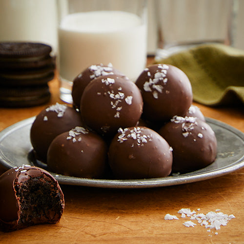 Chocolate Sea Salt Truffles with a glass of milk and a stack of chocolate cookies